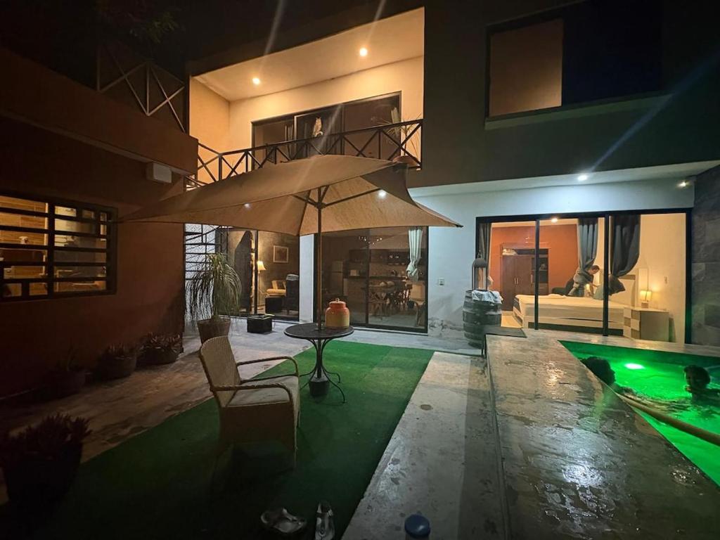 a house with a pool and an umbrella over it at D&B apartments in Lo de Marcos