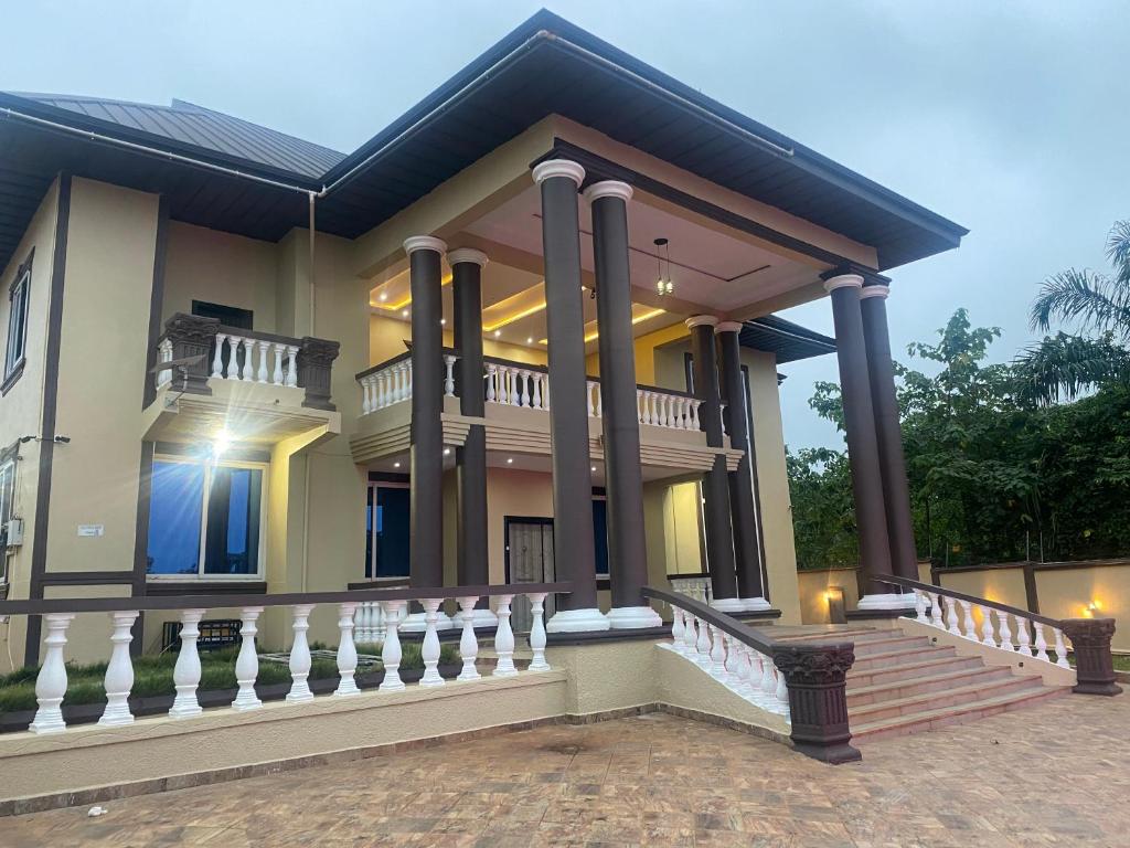 a large house with a staircase in front of it at Nanani Luxury Villa - 3 Bedrooms in Kumasi