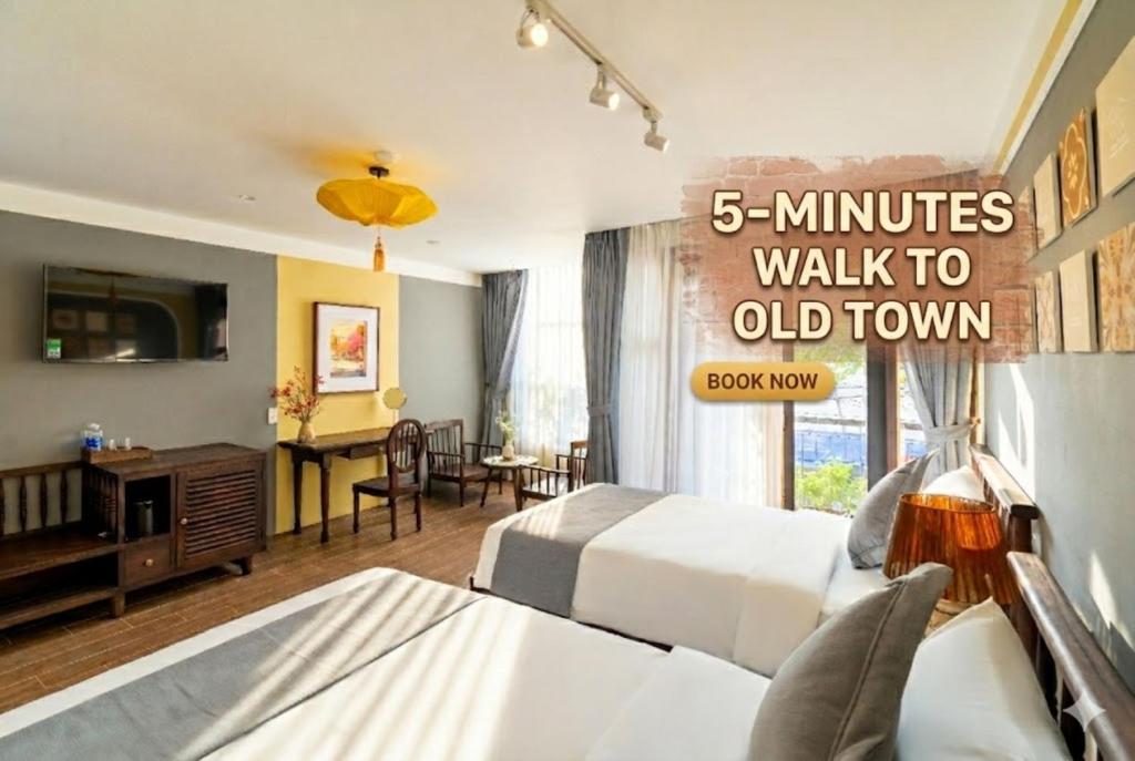 a hotel room with a bed and a desk at Hoianan Boutique Hotel in Hoi An