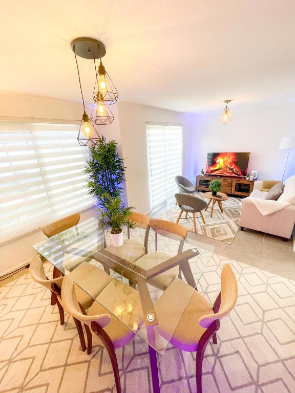 a living room with a table and chairs and a fireplace at Acogedora casa cerca del mar in San Pedro de la Paz