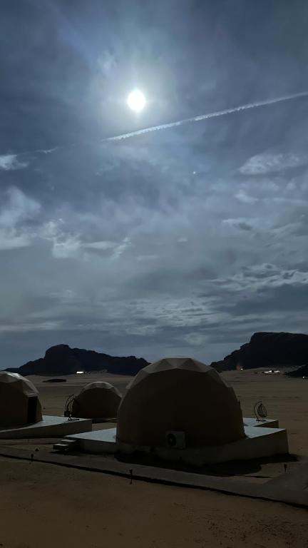 a group of tents in the desert with the sun in the sky at Star night in Disah