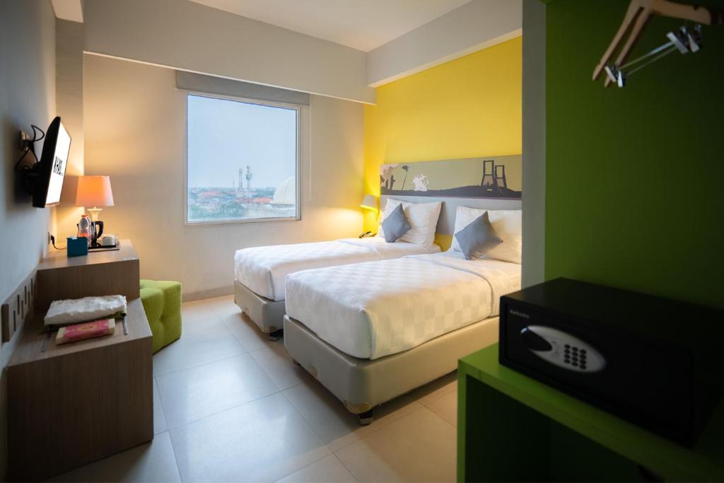 a hotel room with a bed and a window at KHAS Surabaya Hotel in Surabaya