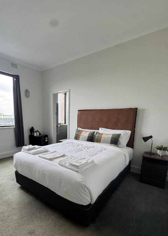 a bedroom with a large bed with white sheets at Amaroo Hotel Dubbo in Dubbo