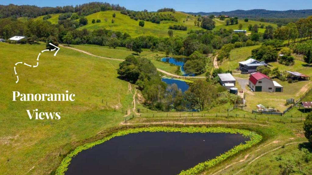 an aerial view of a farm with a pond at Hinterland Hideaway Farm Stay in Wolvi