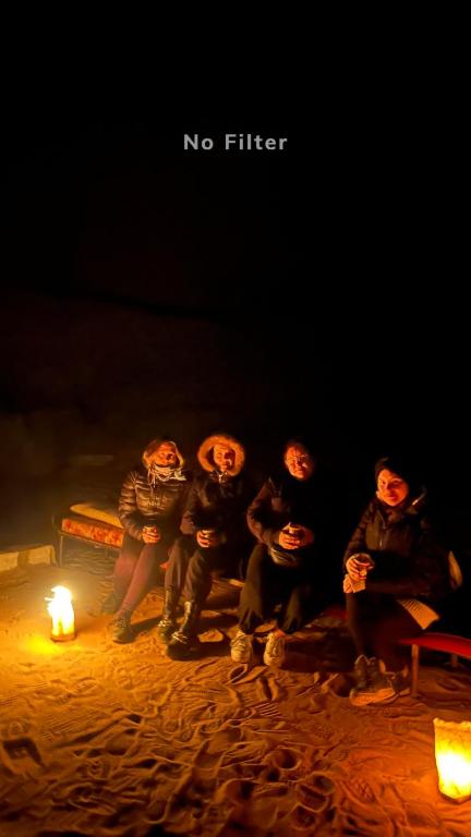 a group of people sitting next to a fire at Sunset mountain in Disah