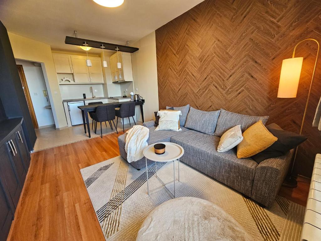 a living room with a couch and a table at One-Bedroom Apartment with Balcony & Fast WiFi in Bansko