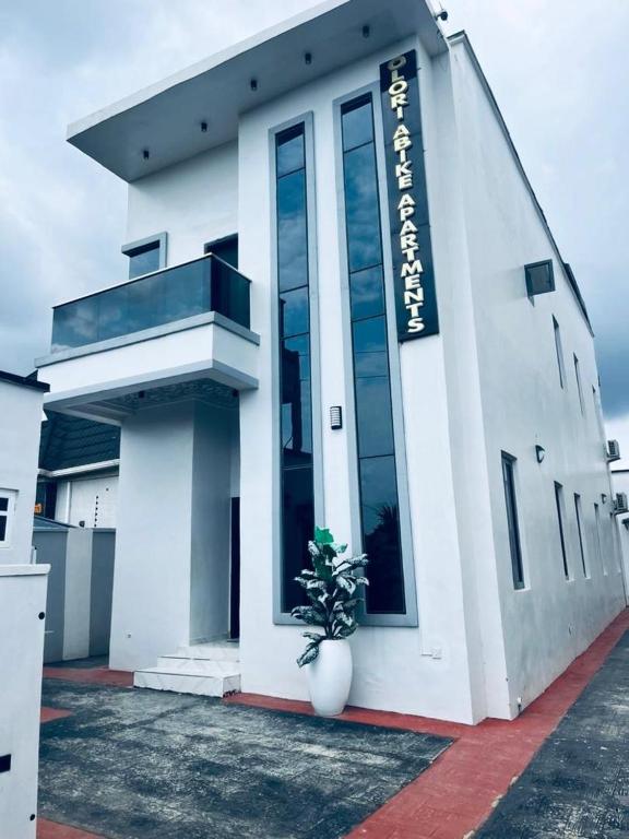 a white building with a plant in front of it at Olori apartments in Adeleye