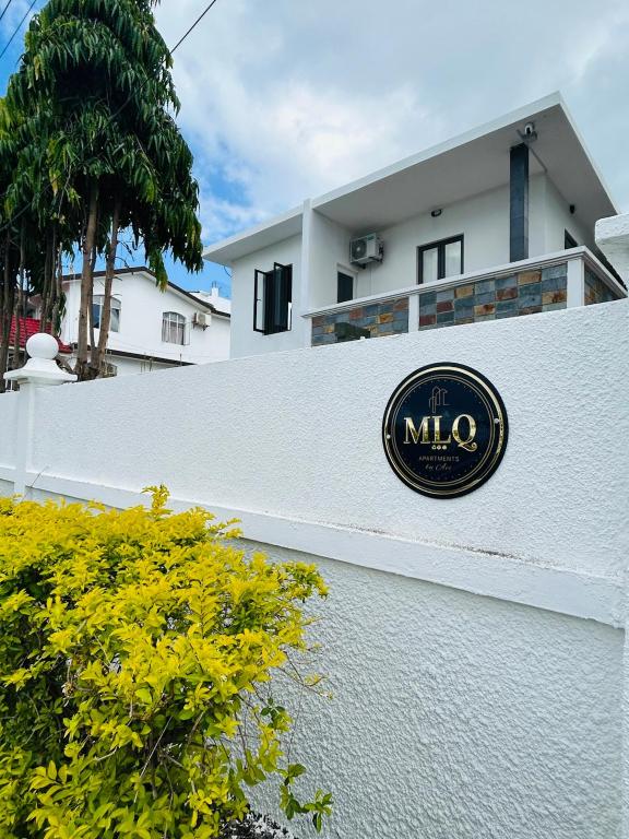 a sign on the side of a white building at MLQ Apartments by Avi in Grand-Baie