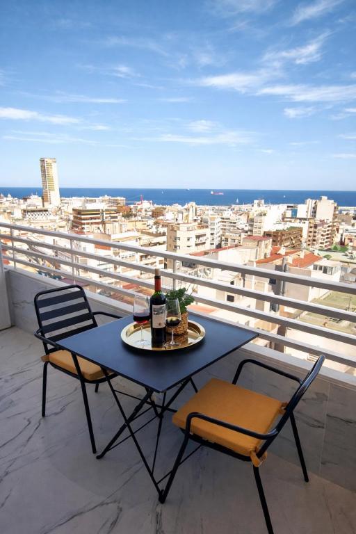 a table with a bottle of wine and two chairs on a balcony at Romantic Sea View Studio with Jacuzzi in Alicante Center in Alicante