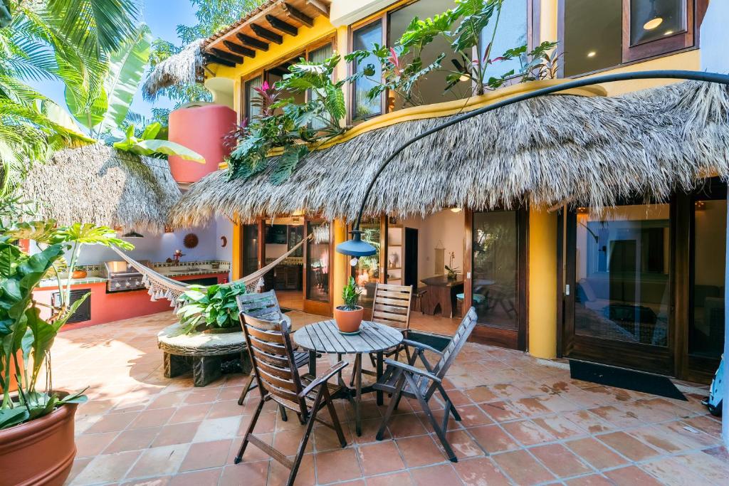 a patio with a table and chairs in front of a house at Amare Las Villas in Sayulita