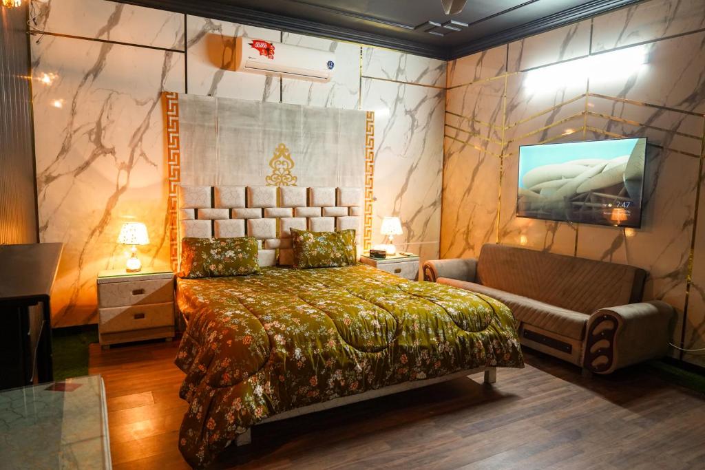 a bedroom with a bed and a tv and a couch at Proxima Quarters in Rawalpindi