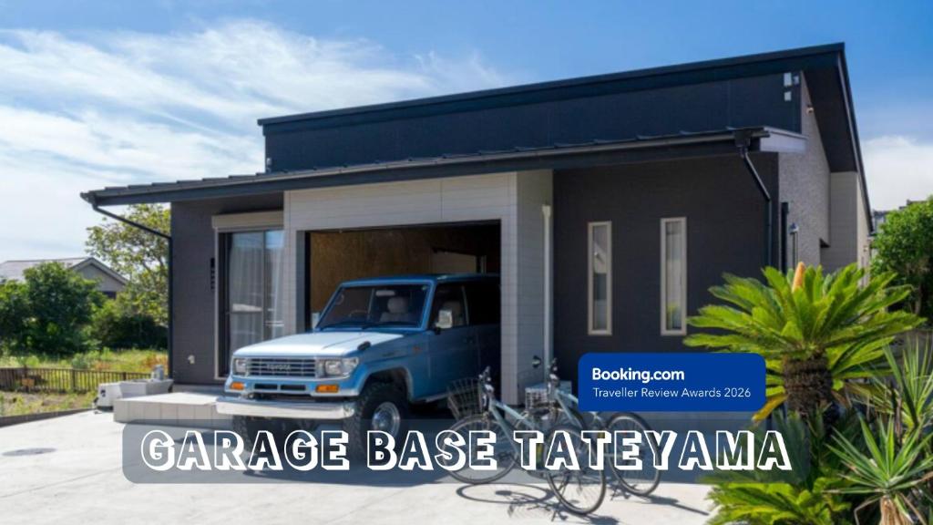 a blue truck parked outside of a small house at Garage Base TATEYAMA in Tateyama