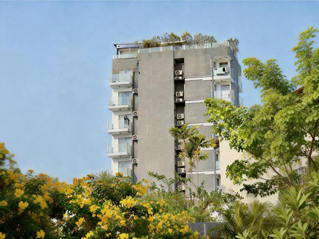 a tall apartment building with trees in front of it at Pentafield City Residence in Amphoe Phra Khanong