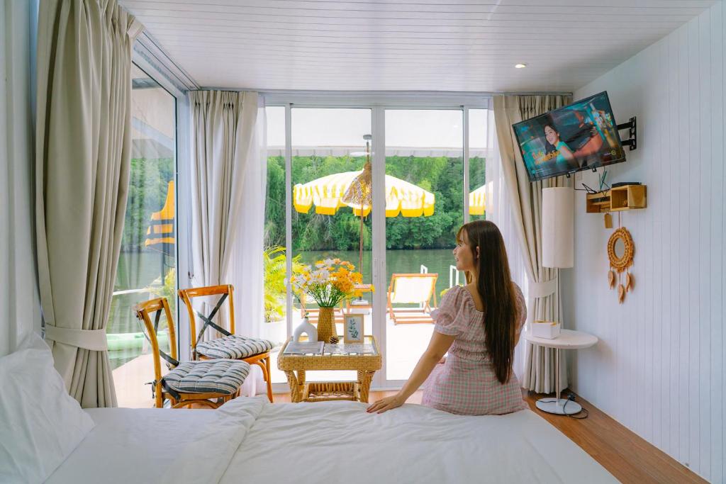 a woman is standing on a bed in a bedroom at Erawan Mountain Beach & Maya Erawan & Goodview Erawan in Tha Kradan