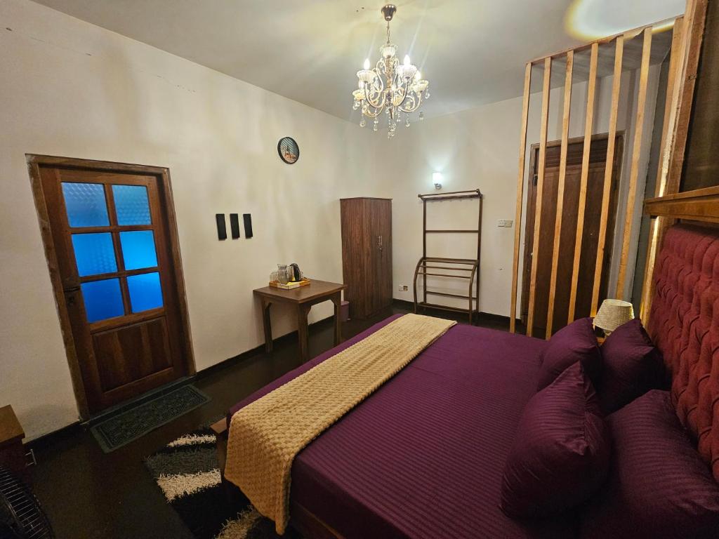 a bedroom with a bed and a chandelier at Bloomy villa in Hatton