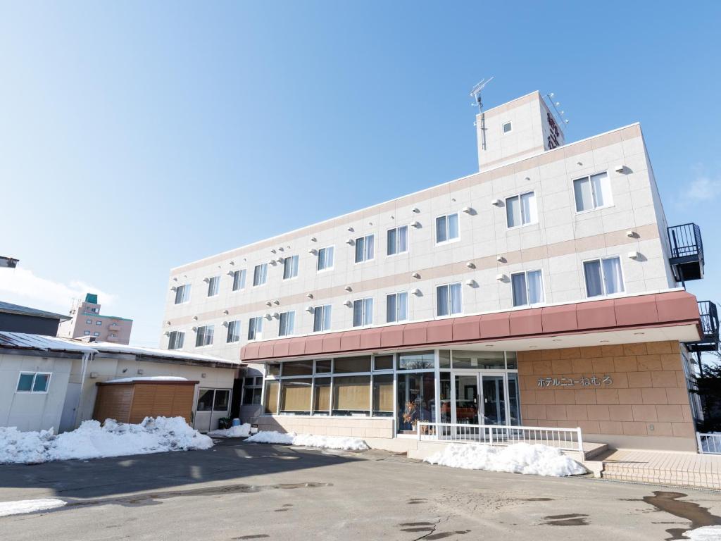 a building with snow on the ground in front of it at Tabist Hotel New Nemuro in Nemuro