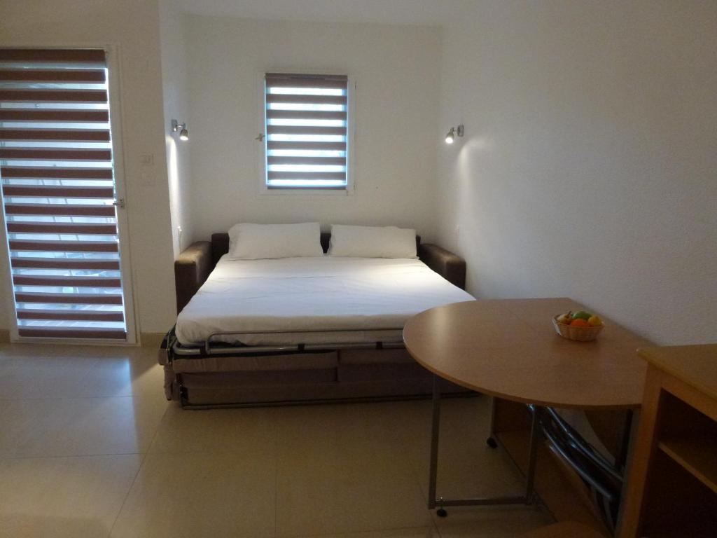 um pequeno quarto com uma cama e uma mesa em Residence Les Palmiers em Nice