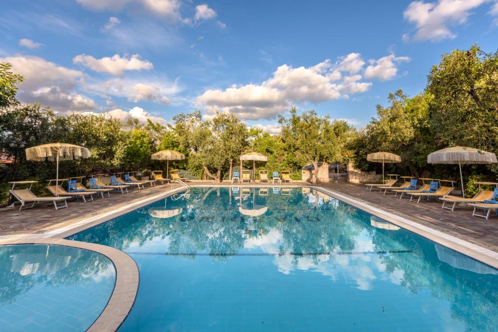 una piscina in un resort con sedie e ombrelloni di Il Giardino a Foce Varano
