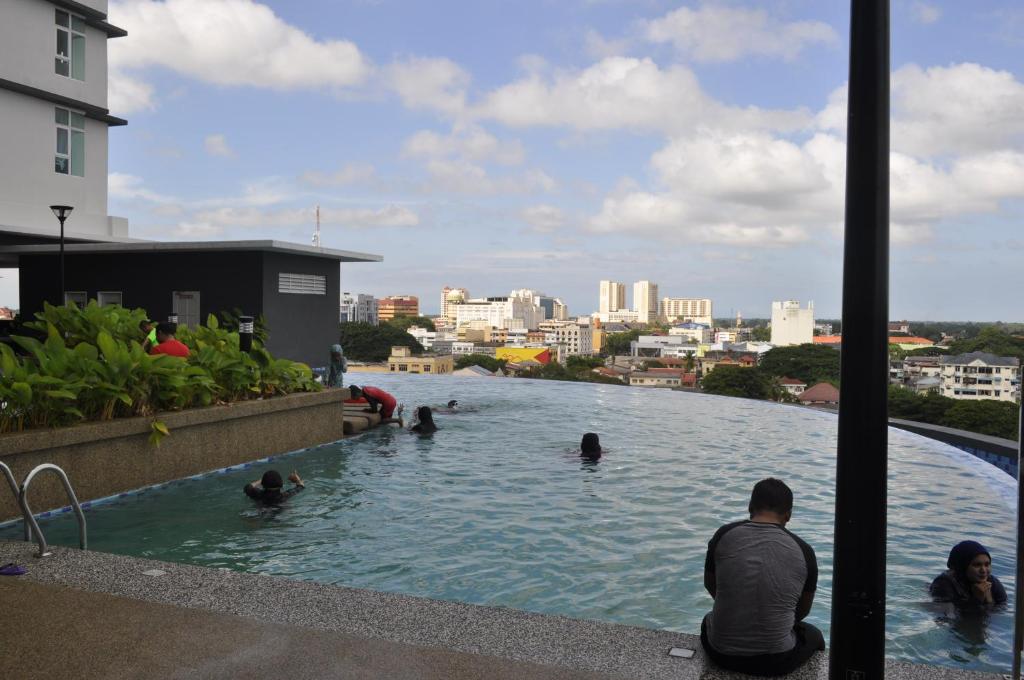 people swimming in a swimming pool in a river at D'Perdana Residence in Kota Bharu