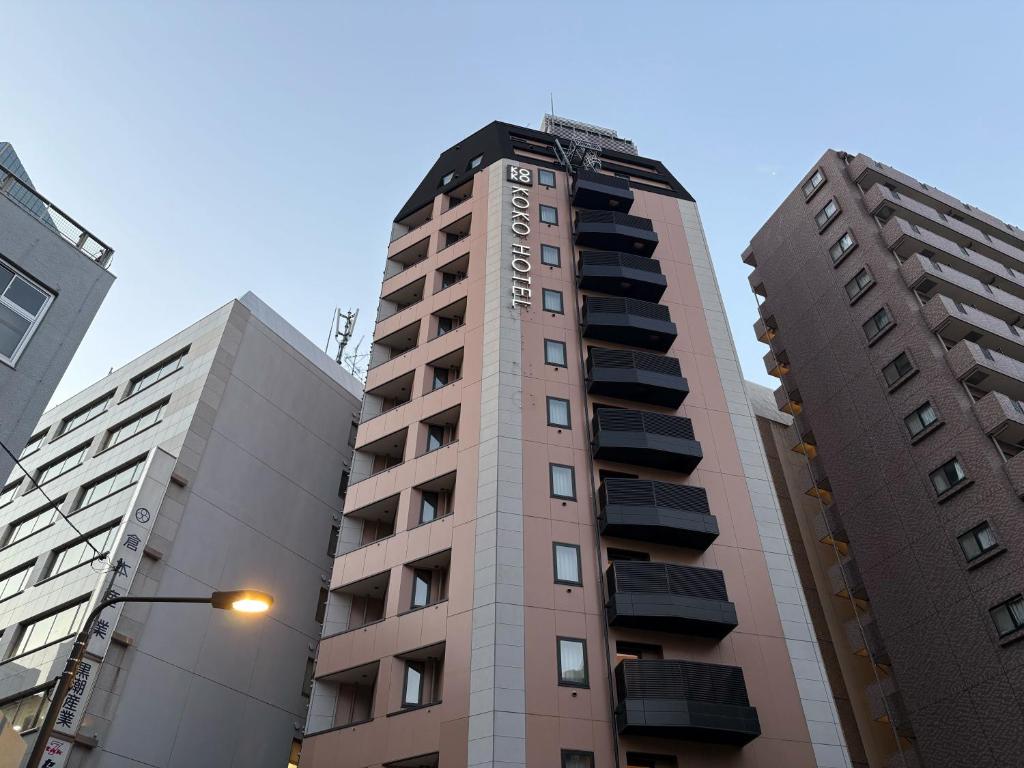 a tall building in the middle of two tall buildings at KOKO HOTEL Ikebukuro in Tokyo