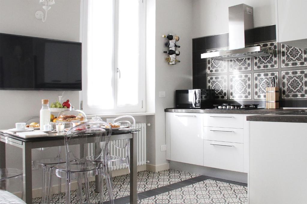 a kitchen with white cabinets and a table with food on it at - Home Sweet Langhe - Room 51 in Alba