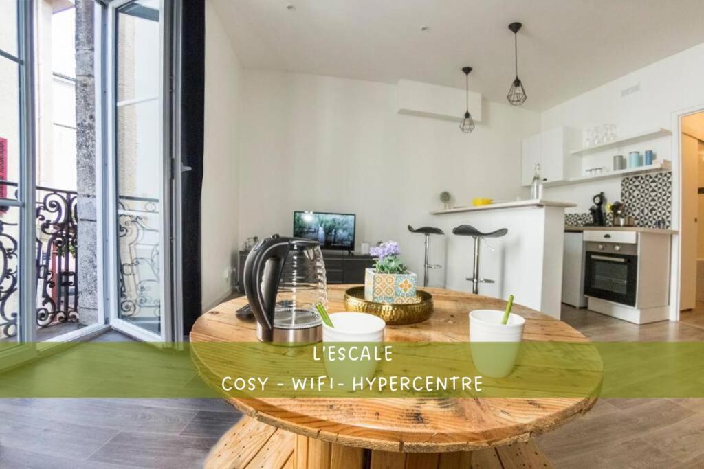 a kitchen with a wooden table in a room at L'escale - Centre ville - 3 étoiles in Bourg-en-Bresse