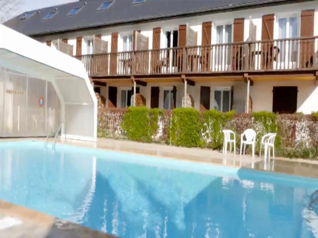 a hotel with a swimming pool in front of a building at Auberge de la Vallée d'Ossau in Izest