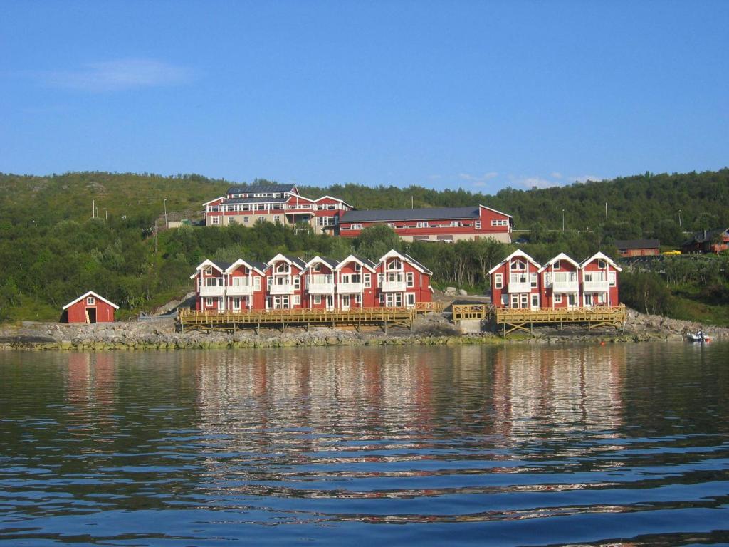 una fila de casas en la orilla de un cuerpo de agua en Tjeldsundbrua Hotel, en Evenskjer