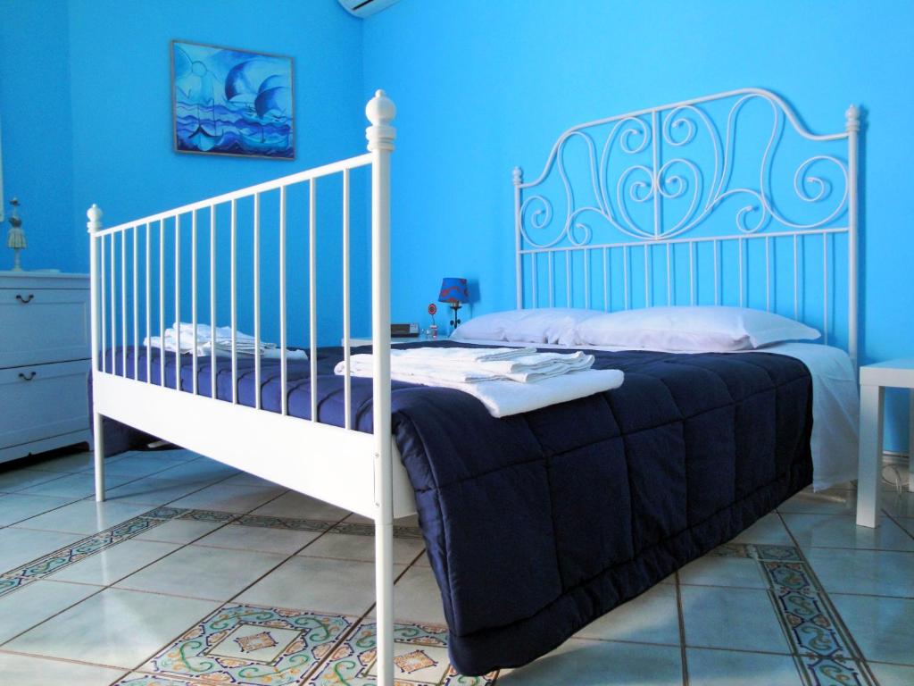 een slaapkamer met een wit bed en blauwe muren bij Garibaldi Holiday House in Napels