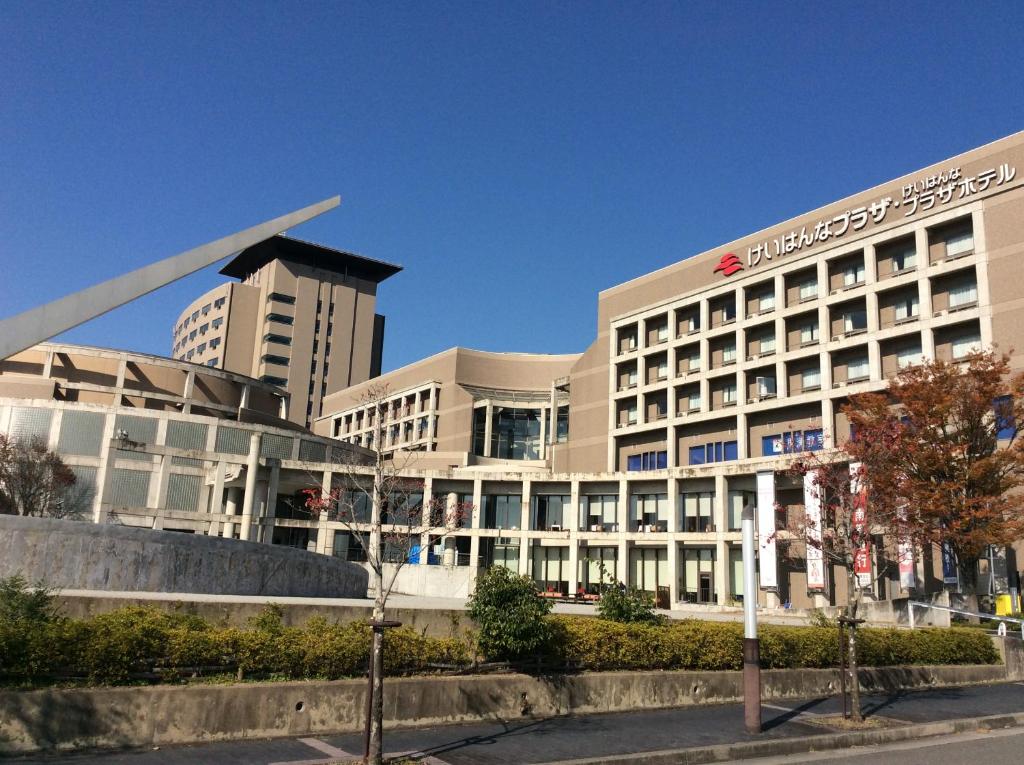 a large white building with a sign on it at Keihanna Plaza Hotel in Seika