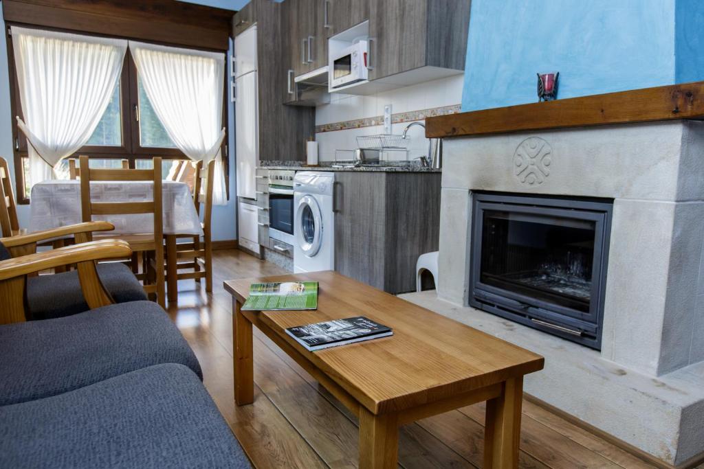 Una sala de estar con un sofá y una chimenea. en La Dobra de liebana, en Cambarco