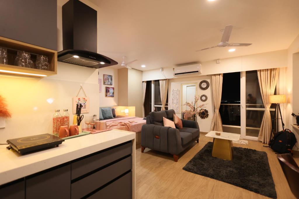 a kitchen and living room with a couch and a table at BlancHaus Stays - Premium Luxury I Viman Nagar I Near Pune Airport I Skyline View in Pune