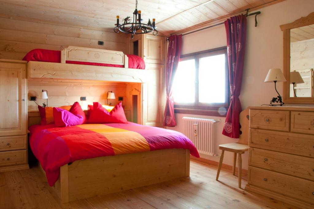 a bedroom with a bunk bed with red and colorful pillows at Profum Di Bosc in Arta Terme