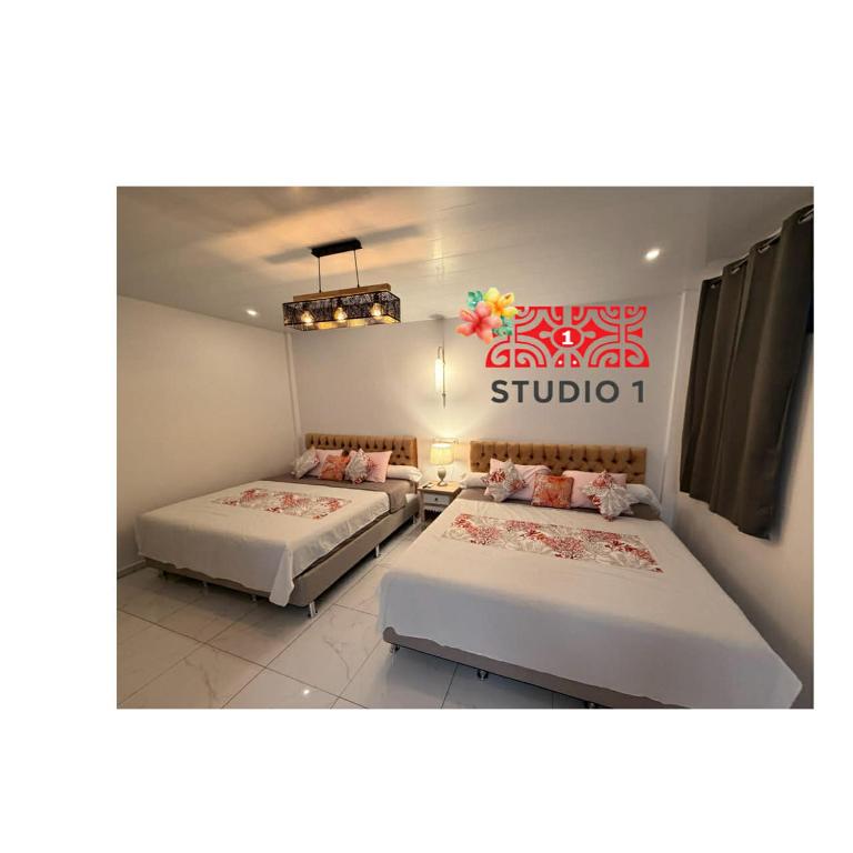 two beds in a room with a sign on the wall at Kahaia stay lodge in Papeete
