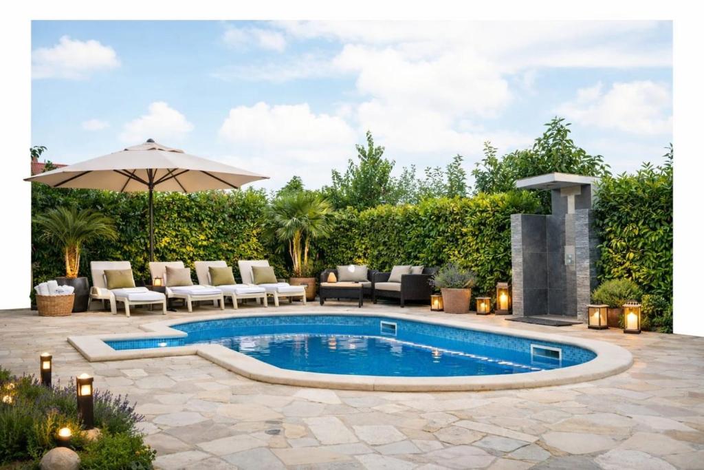 a swimming pool in a yard with chairs and an umbrella at Pula Paradise in Pula