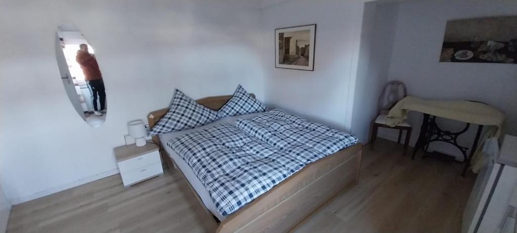 a bedroom with a bed and a person standing in a mirror at Schöne Wohnung in Arnsberg mit tollem Ausblick in Arnsberg