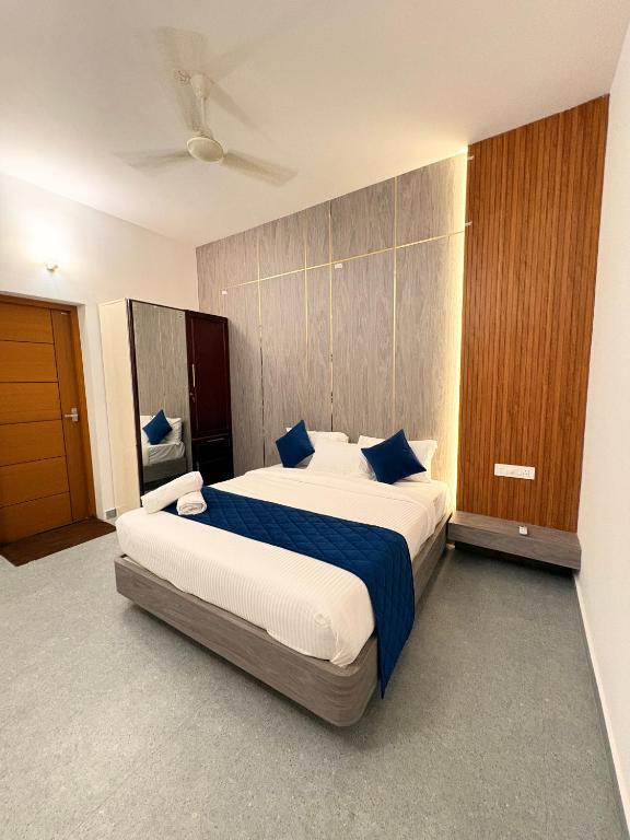 a bedroom with two beds with blue pillows at Thanal Home Stays in Kollam