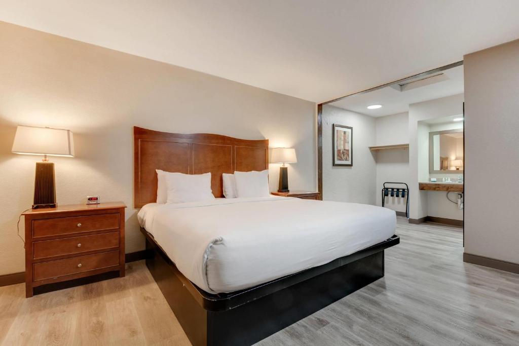 a bedroom with a large bed with a wooden headboard at Suburban Studios near Mesa Verde in Cortez