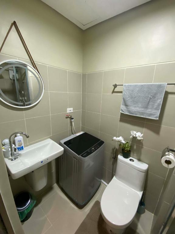 a bathroom with a toilet and a sink and a mirror at AHN Haven in Sampong