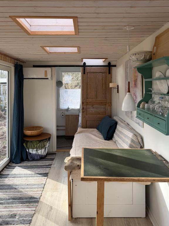 a bedroom with a bed and a table in a room at Tiny house close to Copenhagen in Nybølle