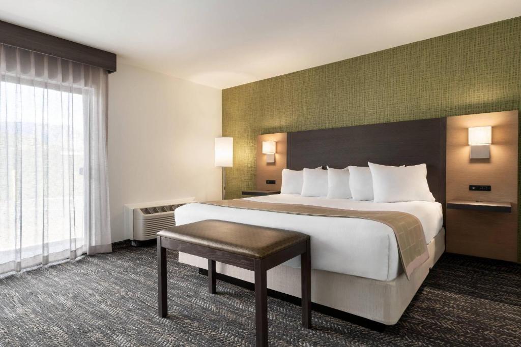a hotel room with a large bed and a table at The Kendrick Hotel, an Ascend Collection Hotel in Flagstaff