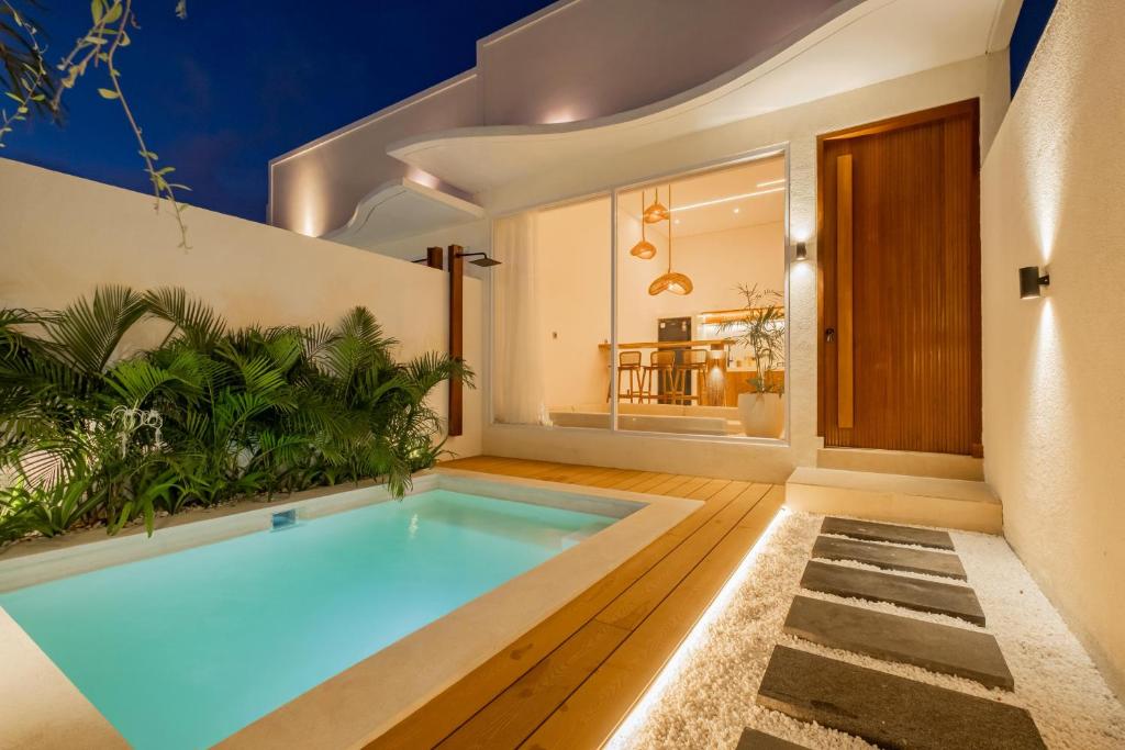 a swimming pool in the middle of a house at Nyaman lima Villas in Canggu