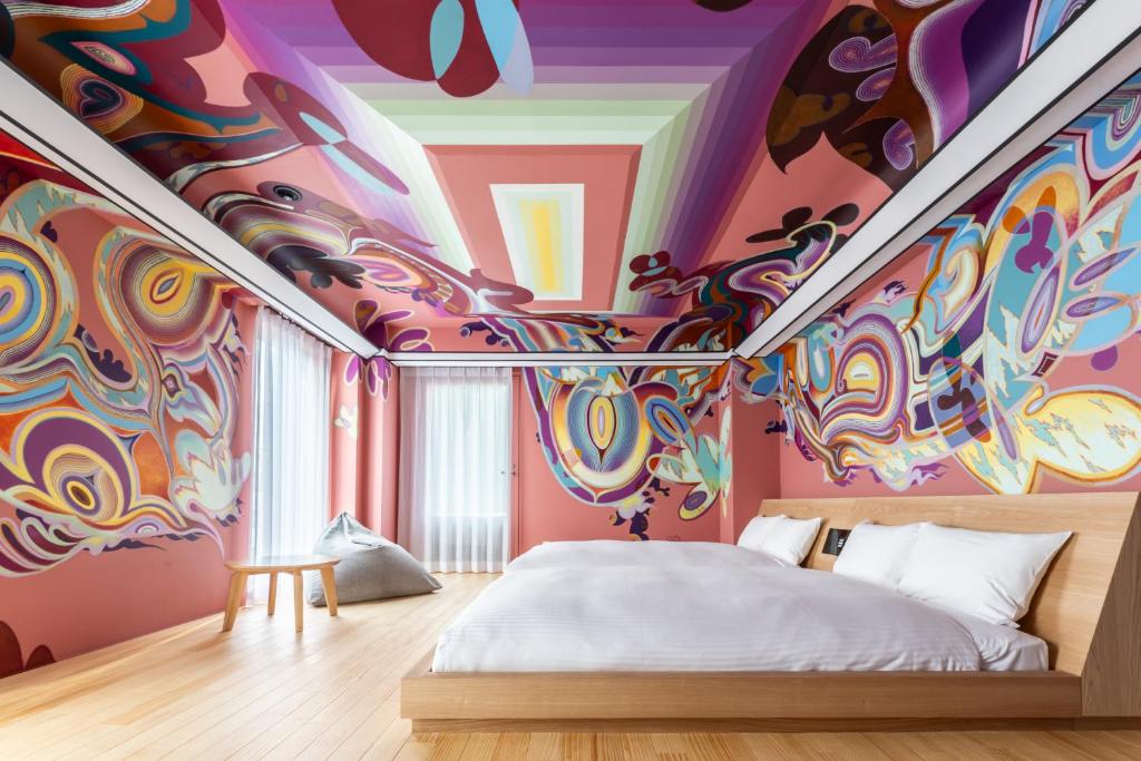 a bedroom with a psychedelic mural on the ceiling at BnA Alter Museum in Kyoto
