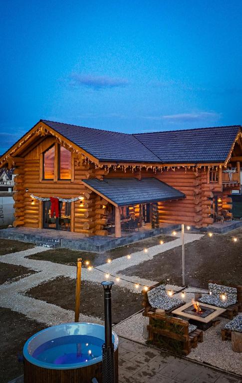 a log cabin with a hot tub in front of it at Sparrow's Nest Spacious Mountain Chalet with Hot Tub and Panoramic Views in Râşnov