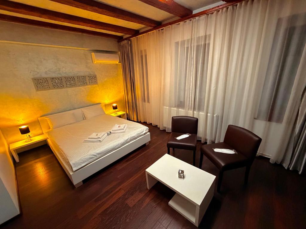 a bedroom with a bed and a table and chairs at Sibiutiful - Ultracentral in Sibiu