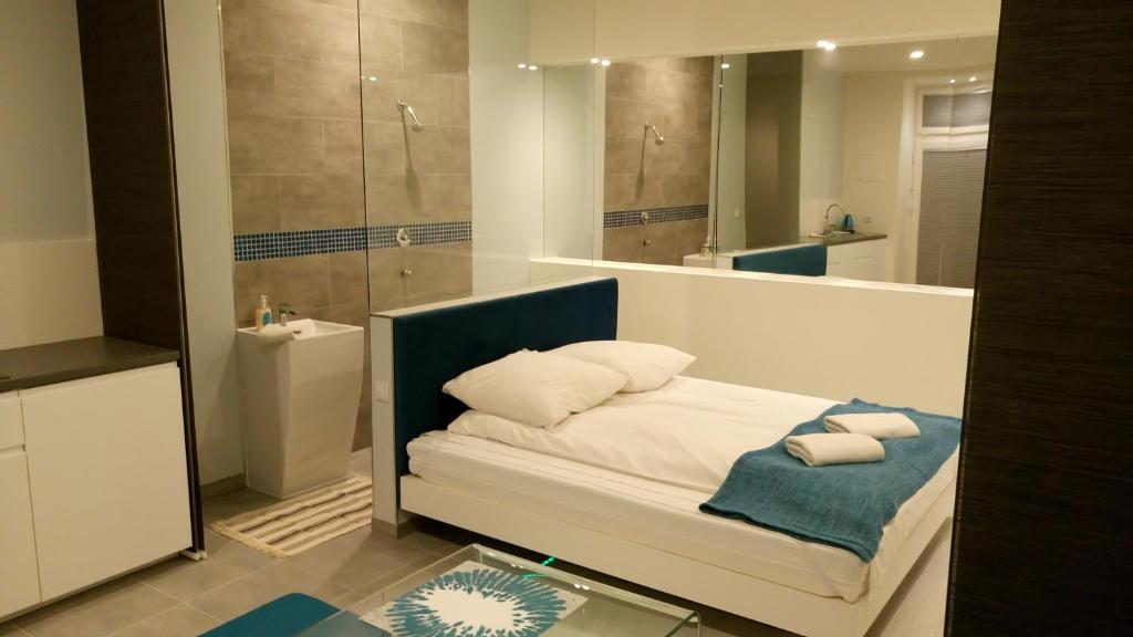 bagno con letto, lavandino e specchio di Mirror Apartments a Cracovia