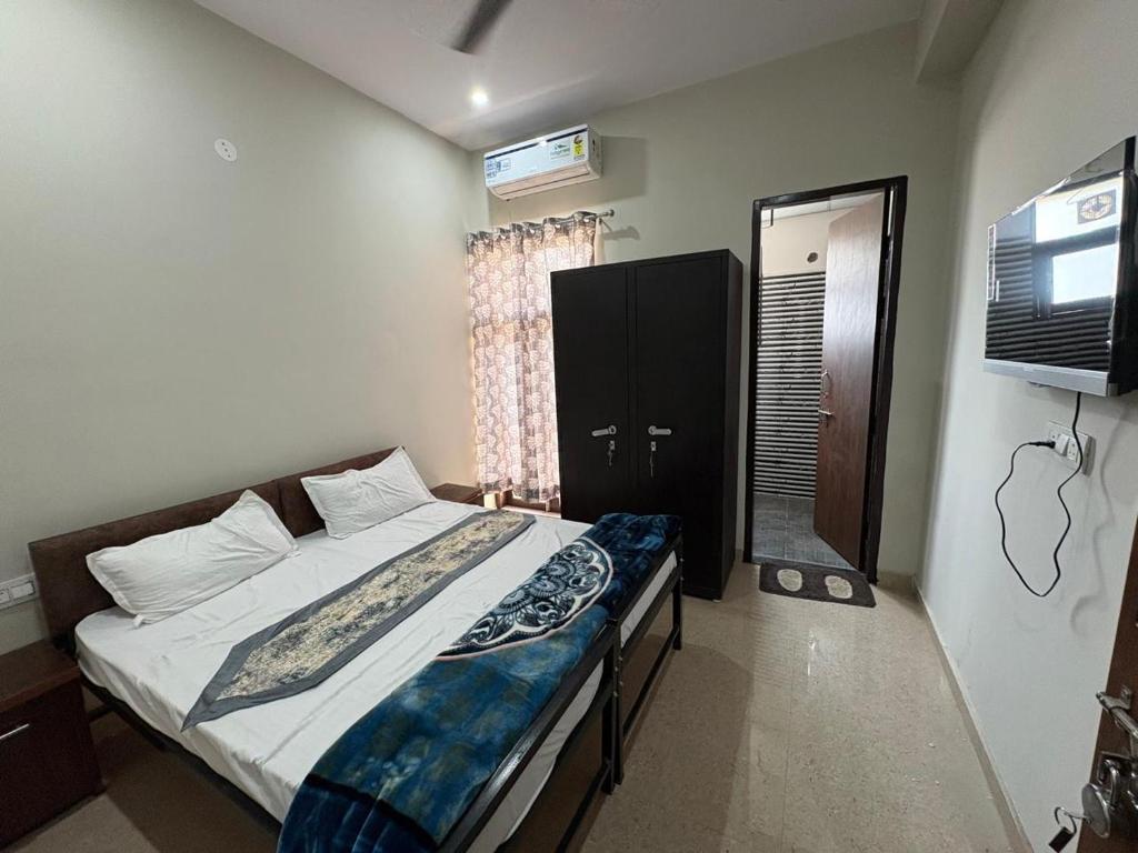 a bedroom with a bed and a television in it at Vansh Residency Couple Friendly Near Rajiv Chowk Gurgaon in Gurgaon