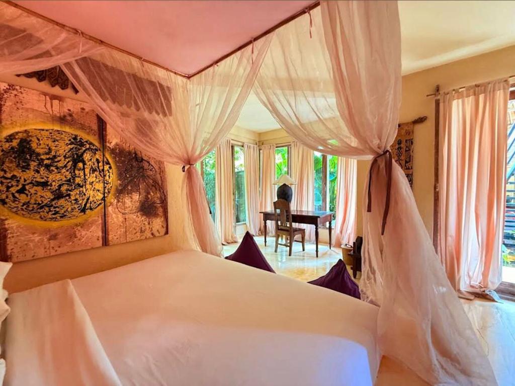 a bedroom with a white bed with a canopy at Villa dengan pemandangan kolam renang in Canggu