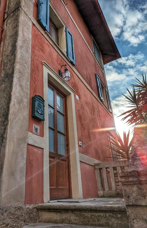 un bâtiment rouge avec une porte sur le côté dans l'établissement Casa Valle - Lago di Garda, à Brenzone