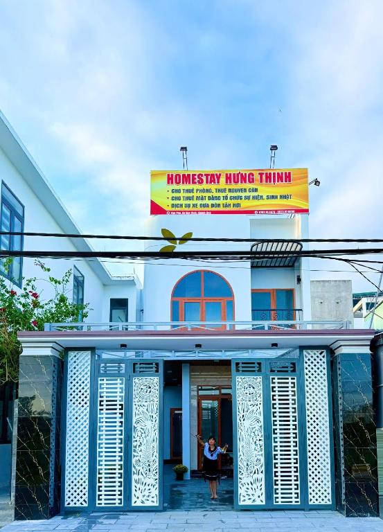 a woman sitting in front of a building at HOMESTAY- Hưng Thịnh in Vạn Ninh